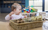 Baby playing with natural materials at Tadpoles Early Childhood Centre