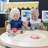 Two boys sitting at a table playing with toys at A pot full of colourful felt tip pens at Tadpoles Early Childhood Centre