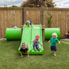 Four toddlers playing on a green slide at Tadpoles Early Childhood Centre