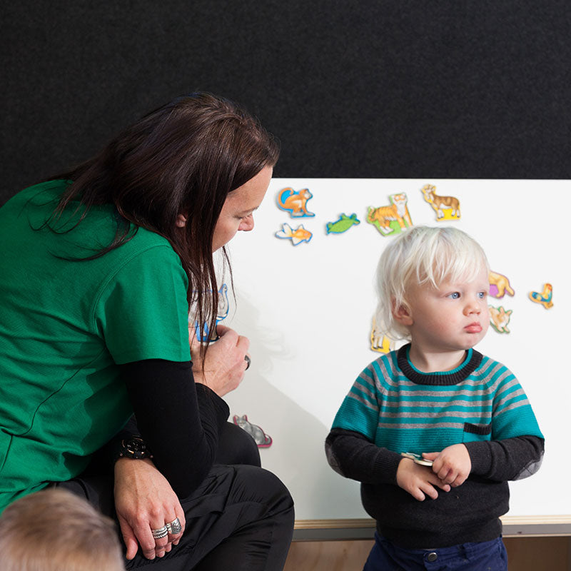Teacher at the blackboard talking to a toddler at Tadpoles Early Childhood Centre