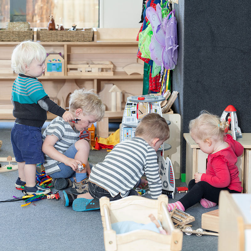 A group of children playing with toys on the ground at A pot full of colourful felt tip pens at Tadpoles Early Childhood Centre