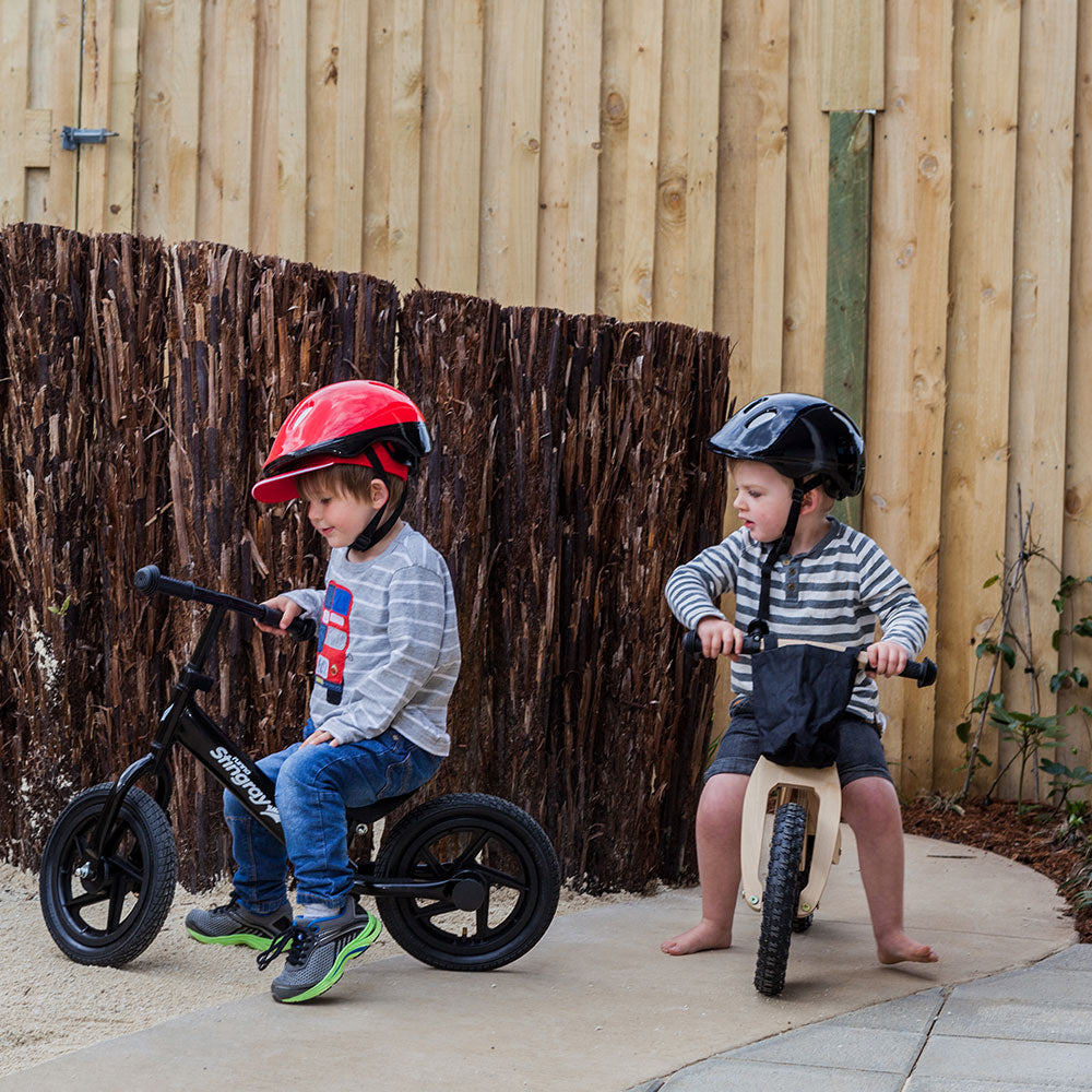 Two boys with helmets riding on bikes at A pot full of colourful felt tip pens at Tadpoles Early Childhood Centre
